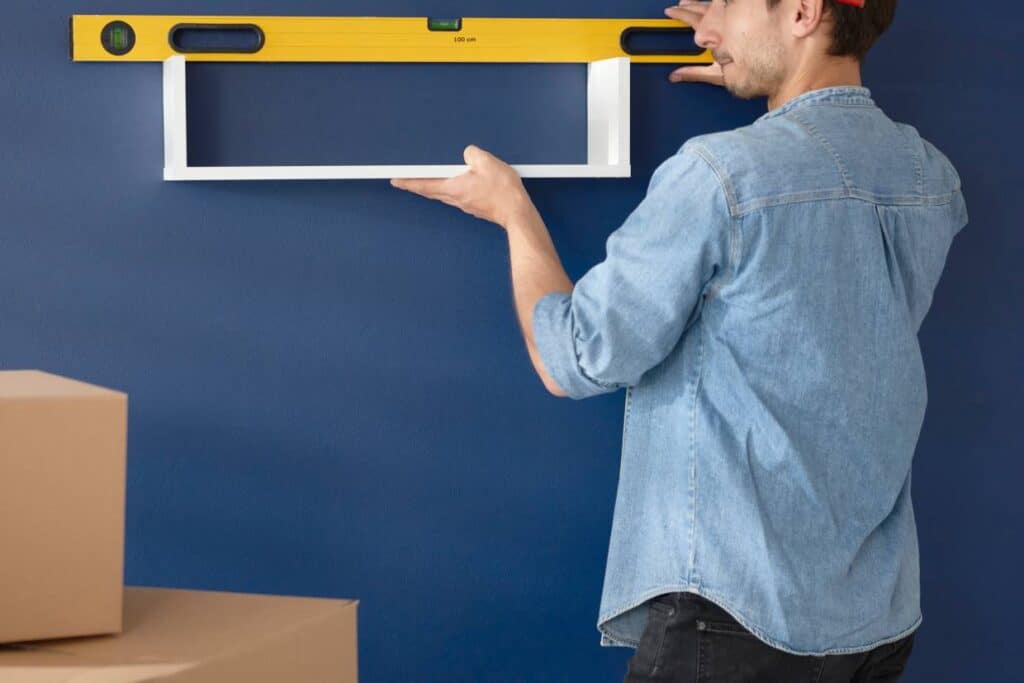 Man checking the spirit level of a shelf